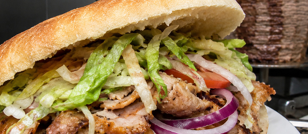 Kebab im Brot mit Fleisch, Salat, Tomaten und Zwiebeln